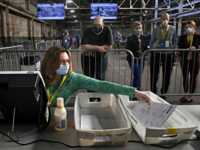 A return board member files a ballot after it was double checked at the Allegheny County Elections Warehouse in Pittsburgh, Pennsylvania, on November 6, 2020.