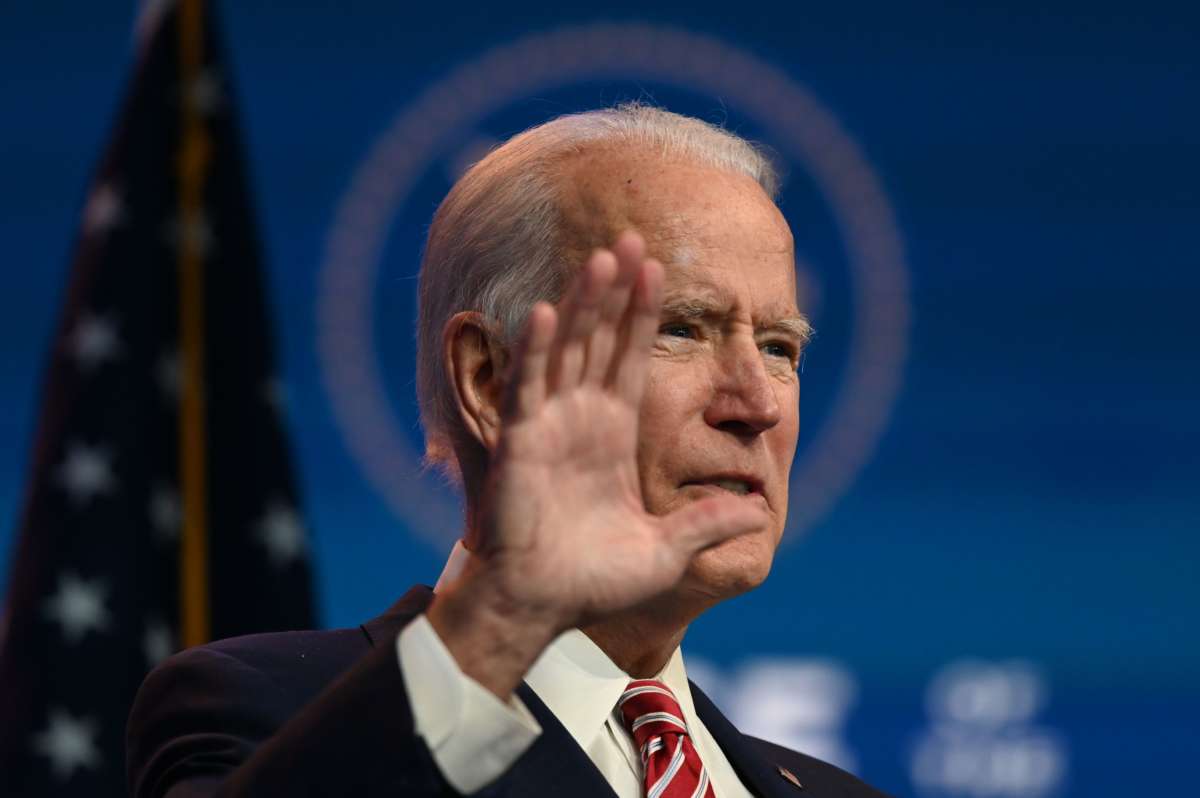 Joe Biden wears a mask and gestures