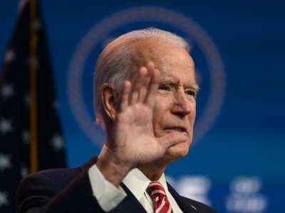 Joe Biden wears a mask and gestures
