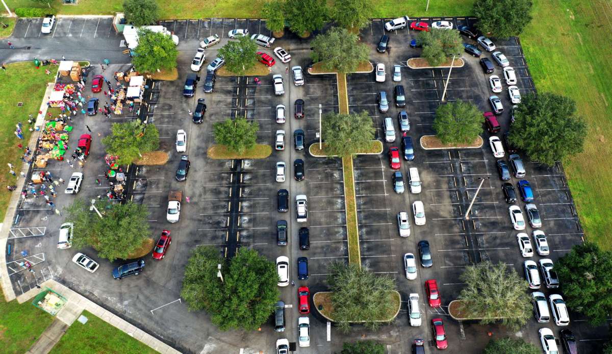 Cars snake across a parking lot for food distribution