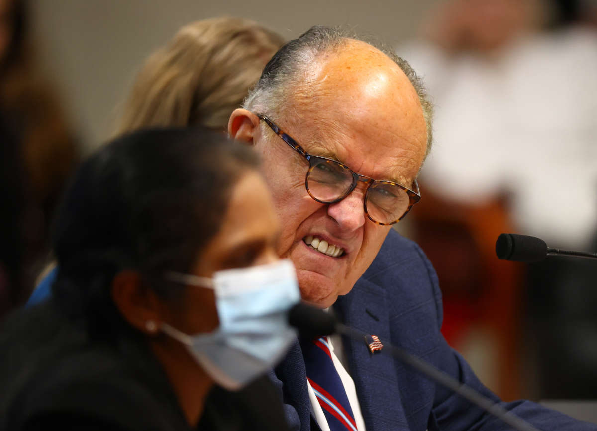 President Trump's personal attorney Rudy Giuliani listens to a Detroit poll worker during an appearance before the Michigan House Oversight Committee on December 2, 2020, in Lansing, Michigan.