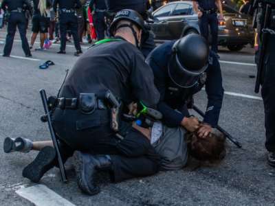 A Police officer arrests Lorises Tercero in front of the U.S. Courthouse during a protest demanding justice for George Floyd, Breonna Taylor and also in solidarity with Portland's protests, in downtown Los Angeles, California, on July 25, 2020.