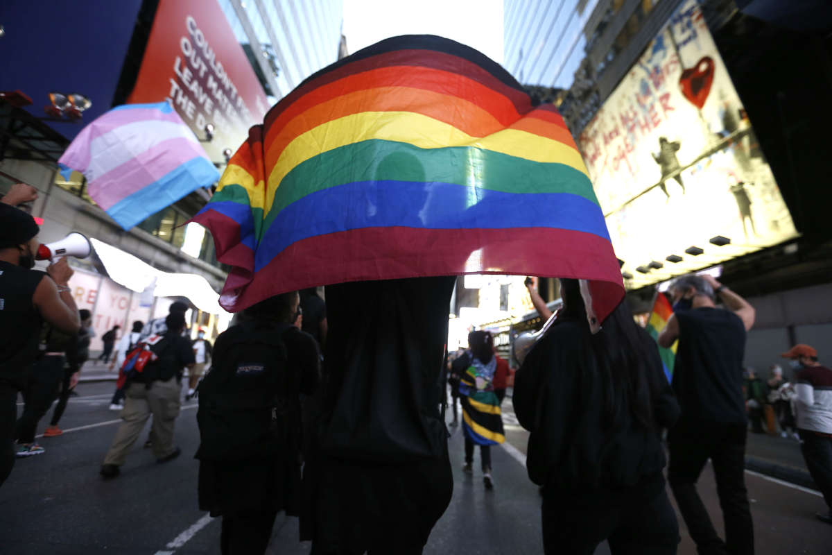 A protester holds a rainbow flag in support of transgender lives during a demonstration in Times Square against the police shooting of Roxanne Moore, a transgender woman.