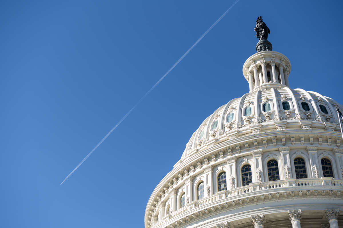 A jet leaves a contrail over the Capitol dome as Congress holds the last votes of the week before the Thanksgiving recess on November 20, 2020.