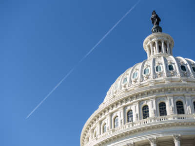 A jet leaves a contrail over the Capitol dome as Congress holds the last votes of the week before the Thanksgiving recess on November 20, 2020.