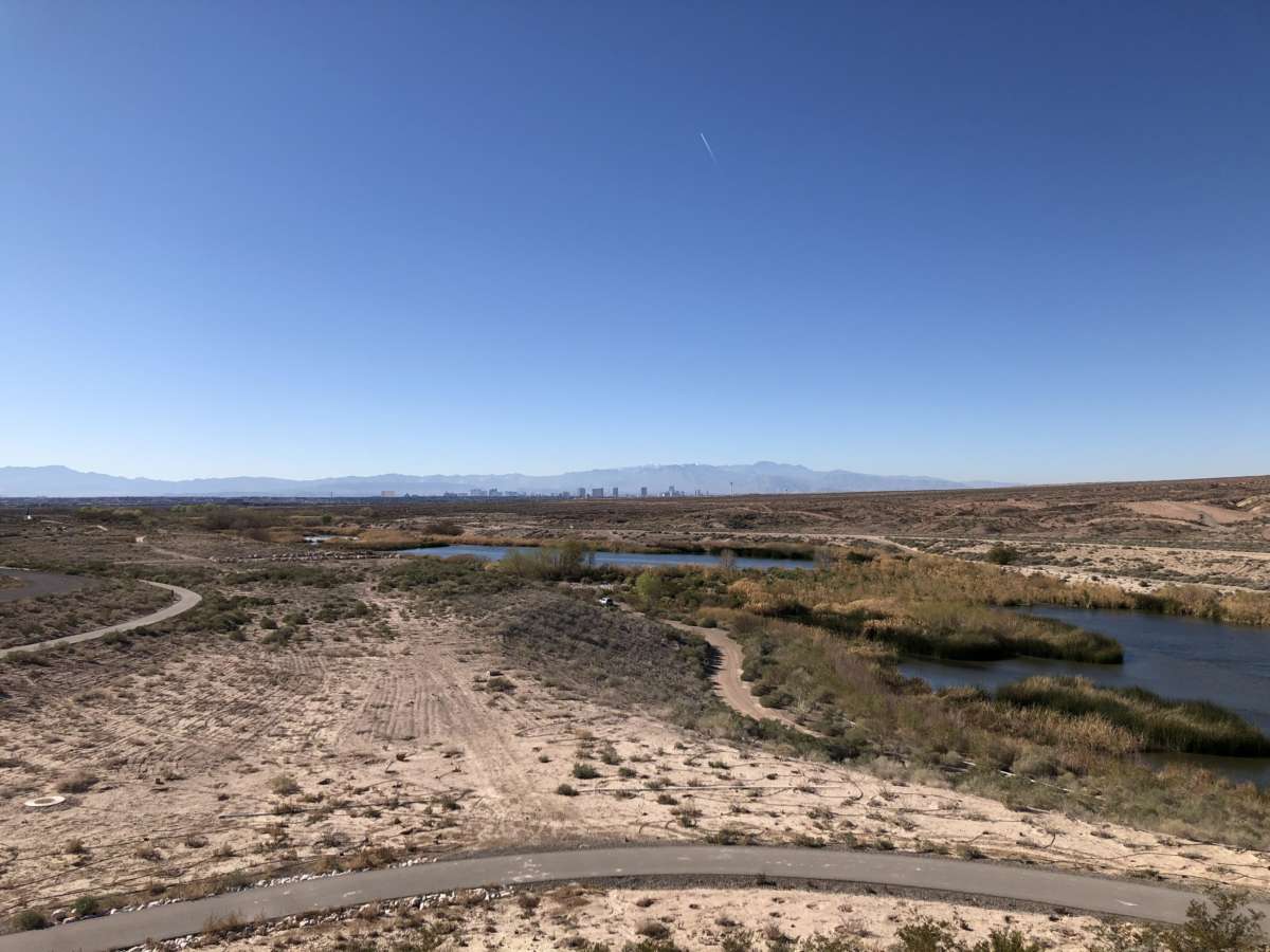 A road cuts through dry land surrounding a river