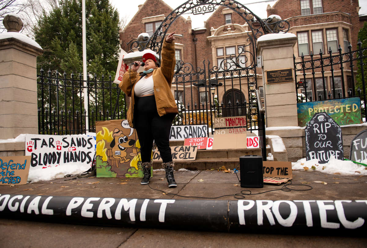An activist speaks into a microphone in front of the Governor's mansion in St. Paul, Minnesota
