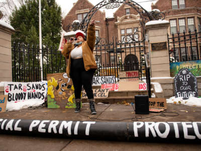 An activist speaks into a microphone in front of the Governor's mansion in St. Paul, Minnesota