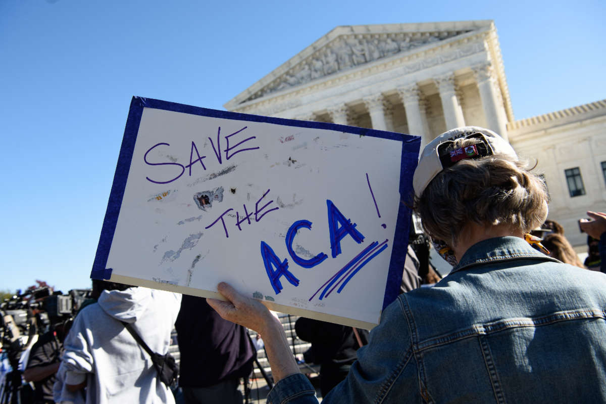 A demonstrator holds a sign in front of the Supreme Court in Washington, D.C., on November 10, 2020.