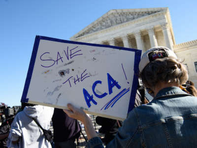 A demonstrator holds a sign in front of the Supreme Court in Washington, D.C., on November 10, 2020.