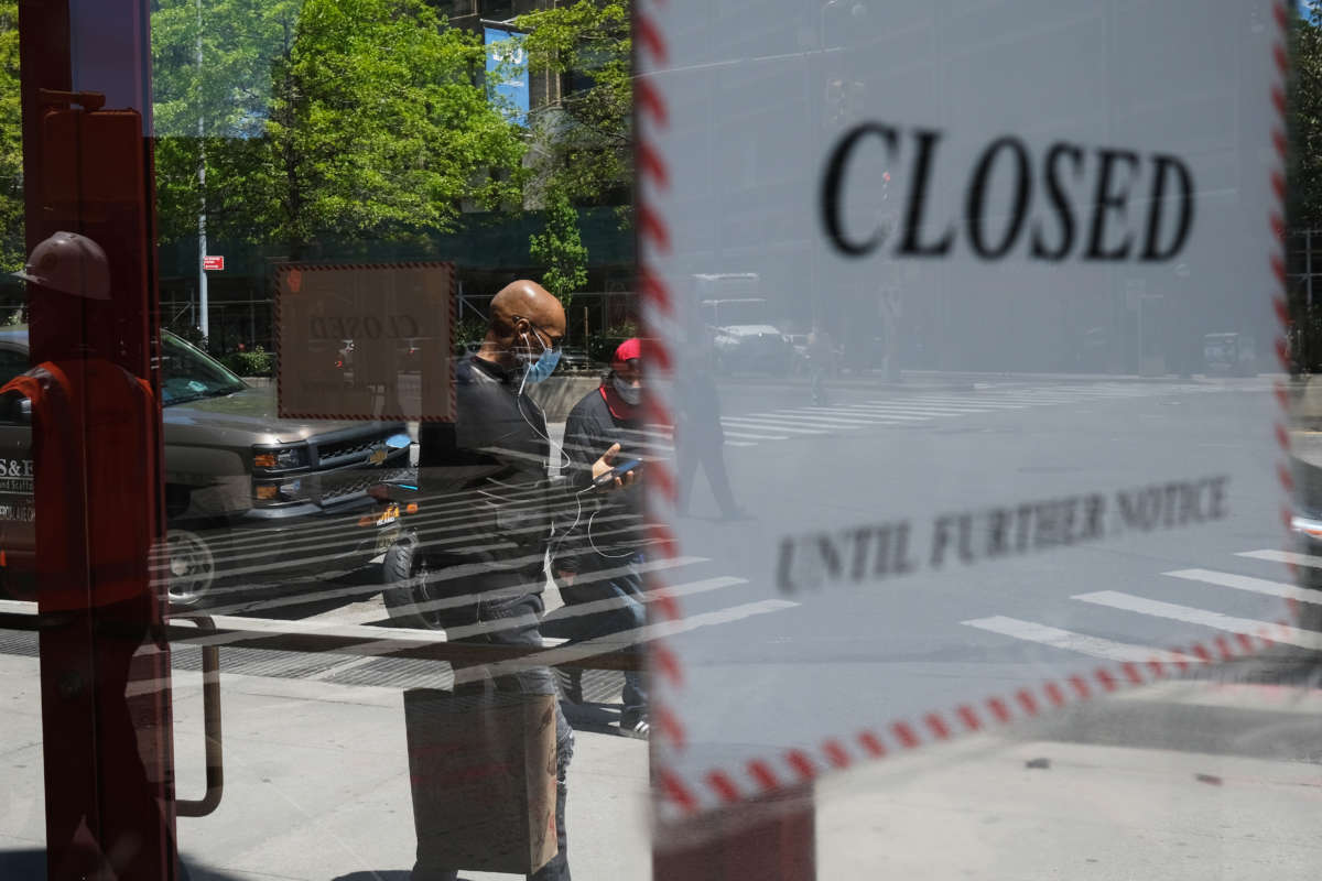 People walk through a shuttered business district in Brooklyn on May 12, 2020, in New York City.