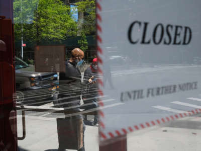 People walk through a shuttered business district in Brooklyn on May 12, 2020, in New York City.