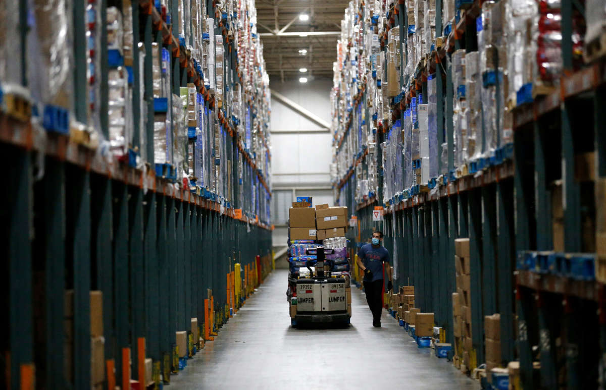 Associates fill orders for both Ralphs and Food 4 Less grocery stores at the Ralphs Distribution Center on April 28, 2020, in Riverside, California.