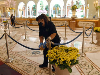 A worker cleans stanchions and ropes in the front desk area of Bellagio Resort & Casino on the Las Vegas Strip on June 4, 2020, in Las Vegas, Nevada.