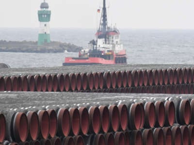 Lengths of pipeline are stacked in piles by the seaside