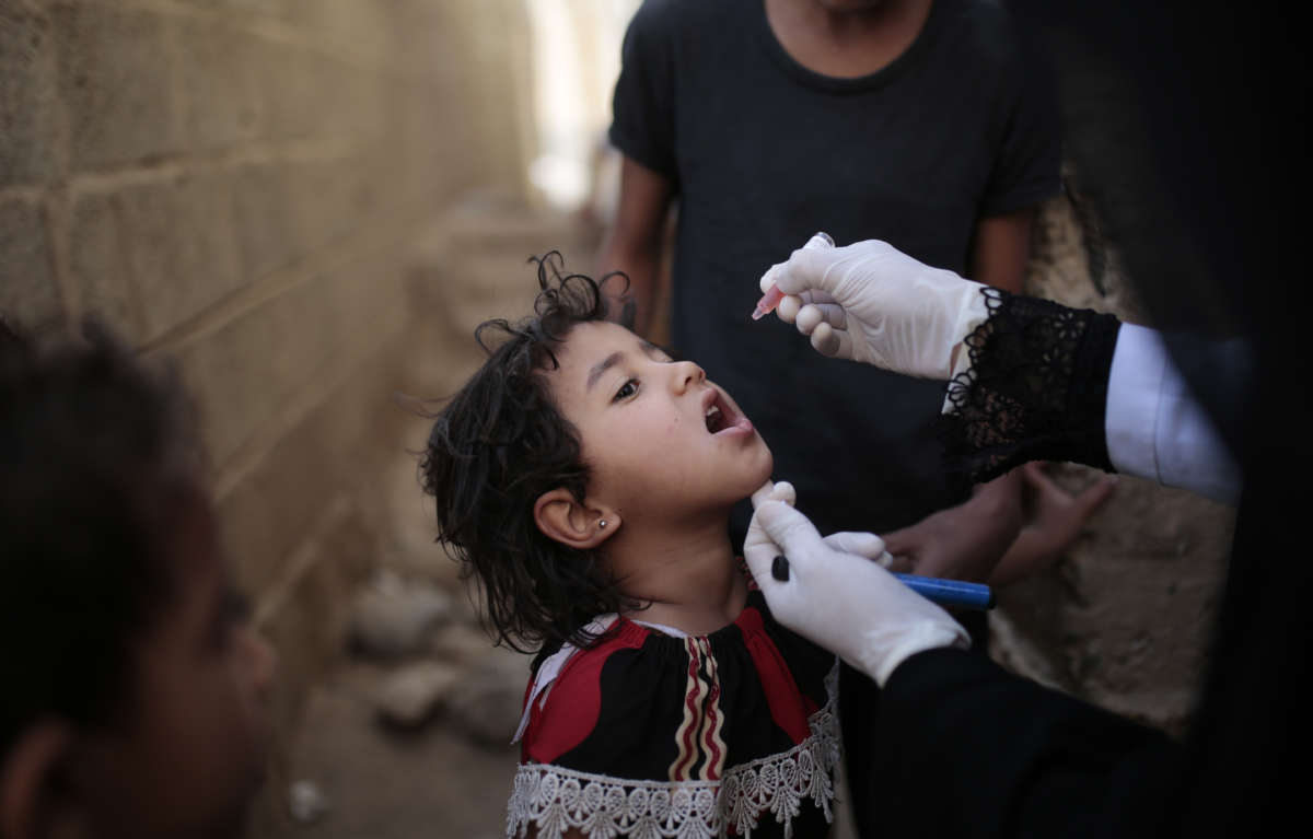 A small child receives a polio vaccine