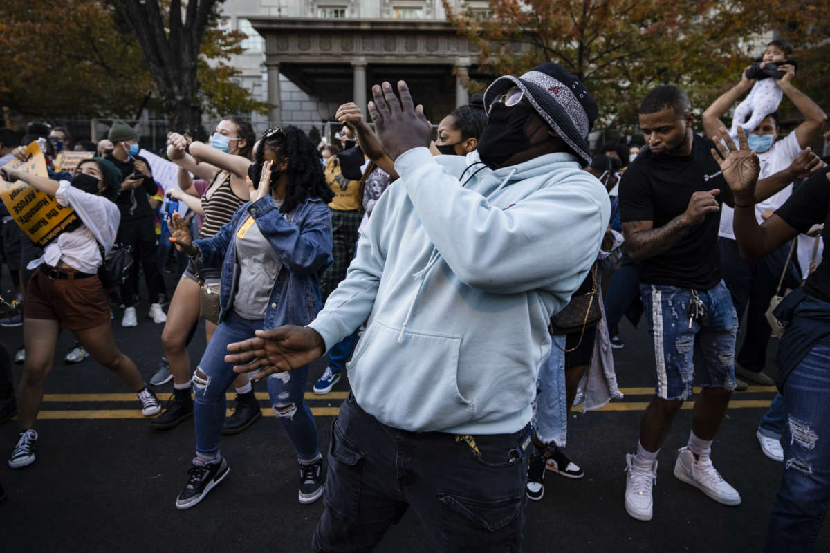 People dance at Black Lives Matter Plaza near the White House as others celebrate on November 8, 2020, in Washington, D.C.