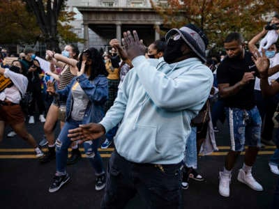 People dance at Black Lives Matter Plaza near the White House as others celebrate on November 8, 2020, in Washington, D.C.