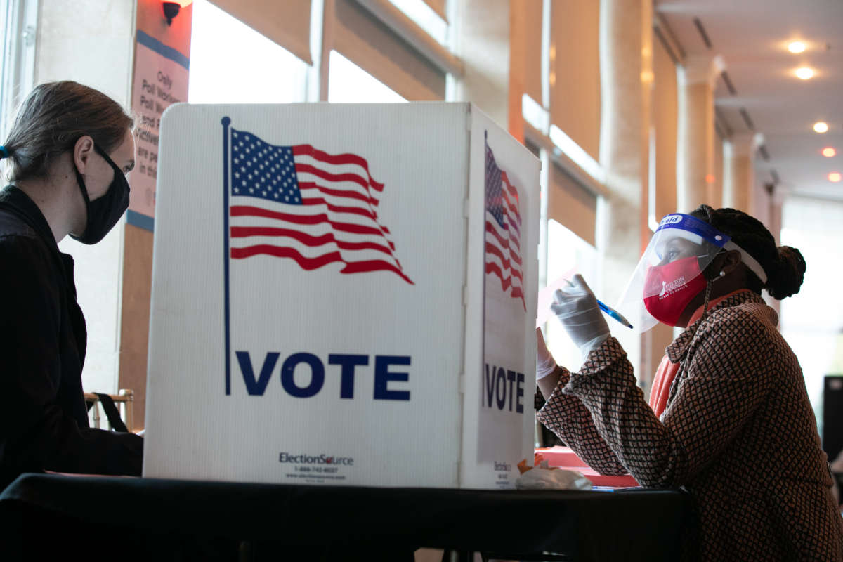 A poll worker helps a voter (left) fill out a provisional ballot at Park Tavern polling station on November 3, 2020, in Atlanta, Georgia.