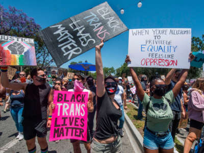 Protesters hold signs and chant slogans at a march against racism and police brutality organized by leaders of black LGBTQ rights groups and attended by a large LGBTQ+ community and supporters, in West Hollywood, California, on June 14, 2020.