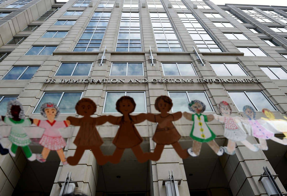 Paper dolls are held by demonstrators protesting outside the Immigration and Customs Enforcement (ICE) headquarters to demand the release of immigrants families in detention centers at risk during the coronavirus pandemic, in Washington, D.C., on July 17, 2020.