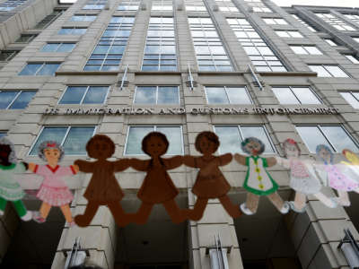 Paper dolls are held by demonstrators protesting outside the Immigration and Customs Enforcement (ICE) headquarters to demand the release of immigrants families in detention centers at risk during the coronavirus pandemic, in Washington, D.C., on July 17, 2020.