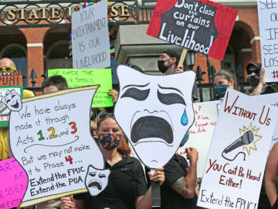 Performance artists rally in front of the the Massachusetts State House in Boston for extended FPUC, the extra $600 provided on top of unemployment during the COVID-19 pandemic, on July 20, 2020.