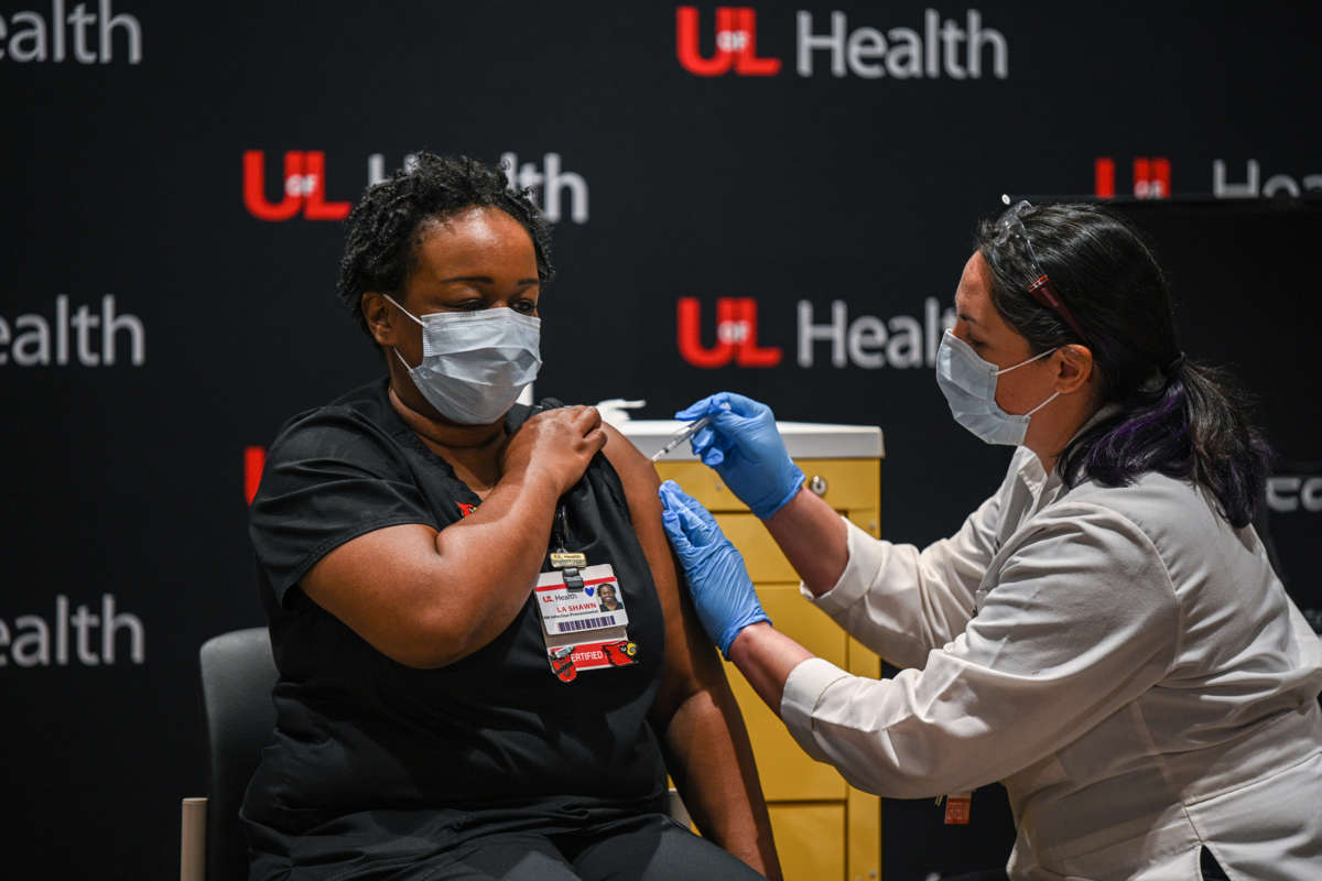 A masked woman is administered with a vaccine