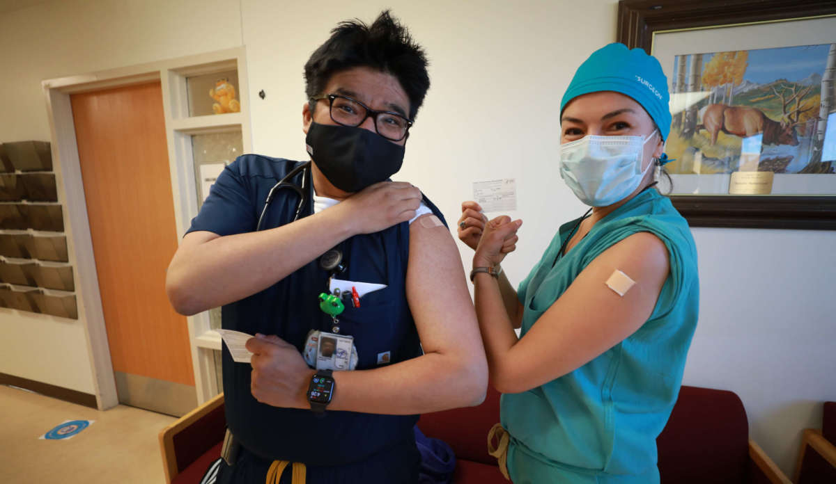 Lance Whitehair (left), a Navajo doctor, and Bijiibaa' Kristin Garrison, a Navajo surgeon, pose for photos after receiving their COVID-19 vaccines at Northern Navajo Medical Center on December 15, 2020, in Shiprock, New Mexico.