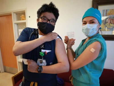 Lance Whitehair (left), a Navajo doctor, and Bijiibaa' Kristin Garrison, a Navajo surgeon, pose for photos after receiving their COVID-19 vaccines at Northern Navajo Medical Center on December 15, 2020, in Shiprock, New Mexico.