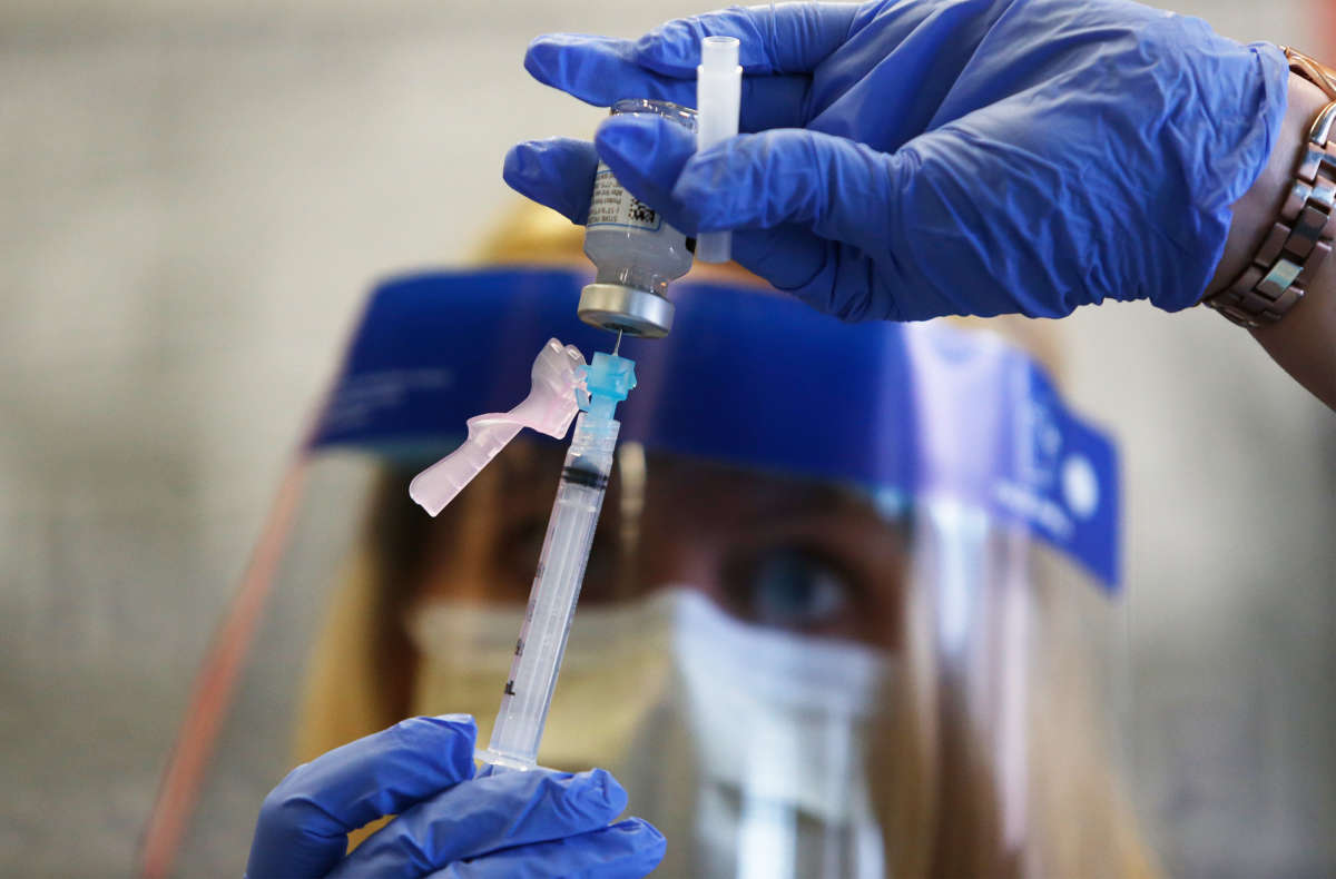 A registered nurse prepares a shot of the Moderna vaccine at East Boston Neighborhood Health Center in Boston, Massachusetts, on December 21, 2020.