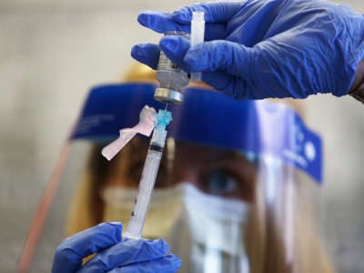 A registered nurse prepares a shot of the Moderna vaccine at East Boston Neighborhood Health Center in Boston, Massachusetts, on December 21, 2020.