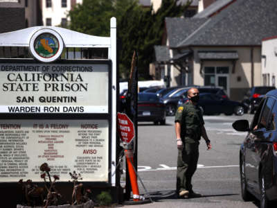 A California Department of Corrections and Rehabilitation (CDCR) officer wears a protective mask as he stands guard at the front gate of San Quentin State Prison on June 29, 2020, in San Quentin, California.