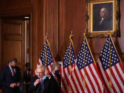 Senate Majority Leader Mitch McConnell removes his face mask as he leads fellow Republican senators into a news conference in the Mansfield Room at the U.S. Capitol on December 1, 2020, in Washington, D.C.