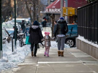 People walk with a child on December 17, 2020, in New York City.