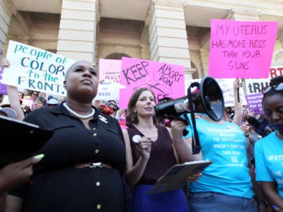 Abortion rights advocates including NARAL Georgia Director Laura Simmons (2nd-L) rally in front of the Georgia State Capitol in Atlanta to protest new restrictions on abortions that were passed in Georgia, on May 21, 2019.