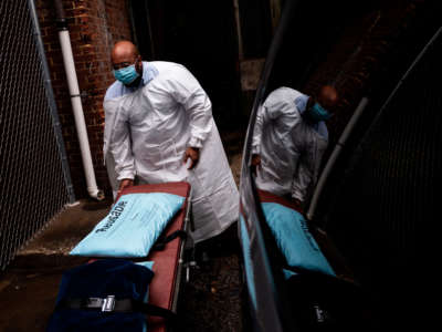Maryland Cremation Services transporter Reggie Elliott folds up a spare gurney after bringing the remains of a COVID-19 victim to his van from the hospital's morgue in Baltimore, Maryland, on December 24, 2020.