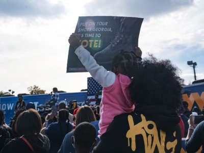 Supporters hold up campaign signs as Democratic Senate candidate Jon Ossoff speaks at a rally on December 19, 2020, in Savannah, Georgia.