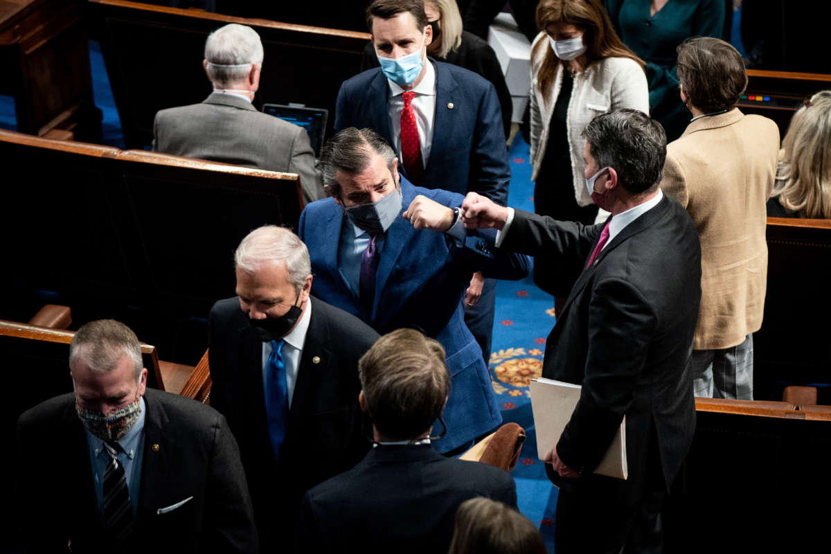 Sen. Ted Cruz fist bumps with a House member during a break in a joint session of Congress to certify the 2020 Electoral College results on January 6, 2021, in Washington, D.C.