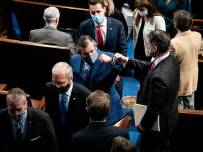 Sen. Ted Cruz fist bumps with a House member during a break in a joint session of Congress to certify the 2020 Electoral College results on January 6, 2021, in Washington, D.C.