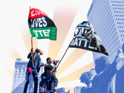 Three protesters wave Black Lives Matter flags during a protest