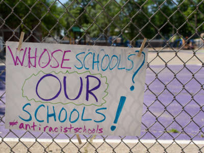 A child’s sign hangs on a school fence during a Day of Solidarity for Antiracist Schools in Madison, Wisconsin.