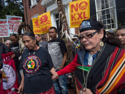 Members of the The Cowboy and Indian Alliance pray while delivering speeches outside then-Secretary of State John Kerry's Gegorgetown house in Washington, D.C., April 25, 2014.