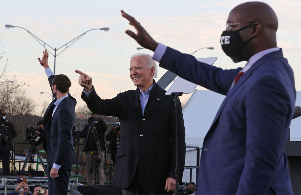 President-elect Joe Biden (C) rallys with Democratic candidates for the U.S. Senate Jon Ossoff (L) and Rev. Raphael Warnock (R) the day before their runoff election in the parking lot of Center Parc Credit Union Stadium, January 4, 2021, in Atlanta, Georgia.