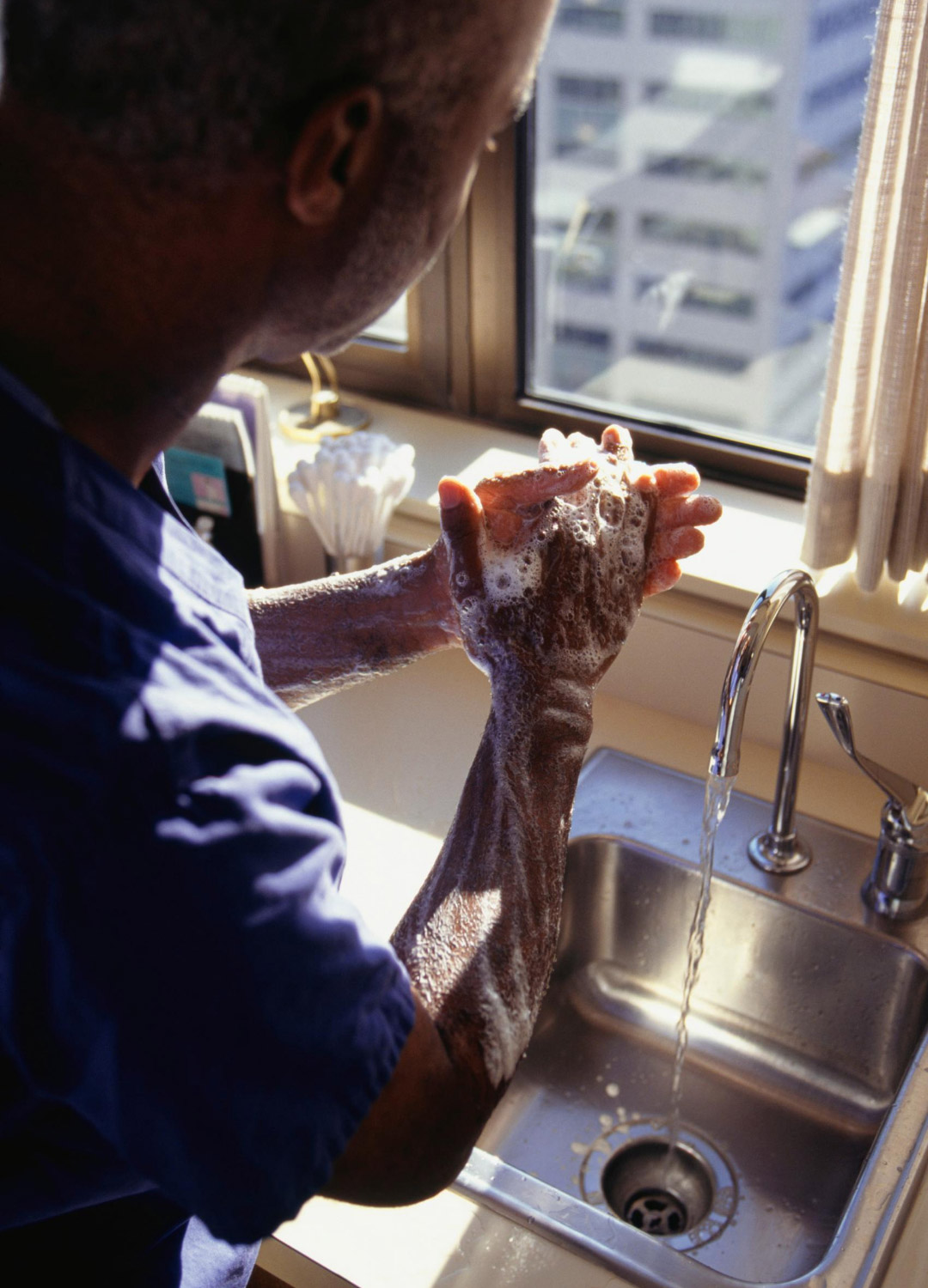 A person washes their hands in sink