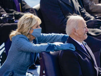 President Joseph Robinette Biden smiles while seated in front of First Lady Dr. Jill Biden