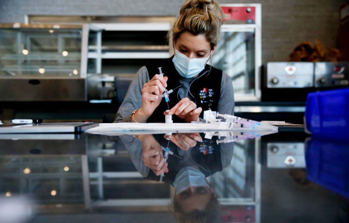 An RN draws up a dose of the Moderna vaccine during the opening day of vaccinations on January 18, 2021, for first responders at the Gillette Stadium / CIC Health COVID-19 Vaccination Site, in Foxborough, Massachussetts.