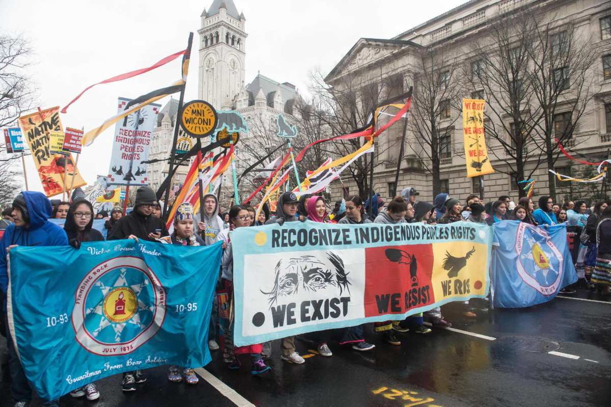 People march past Trump International Hotel during the Native Nations Rise protest on March 10, 2017, in Washington, D.C.