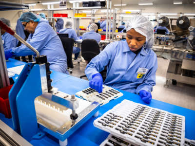 Employees work on the production line of a COVID-19 home test unit that has been granted an Emergency Use Authorization by the U.S. Food and Drug Administration, at the production facility of Australian digital diagnostics company Ellume in Brisbane, December 21, 2020.