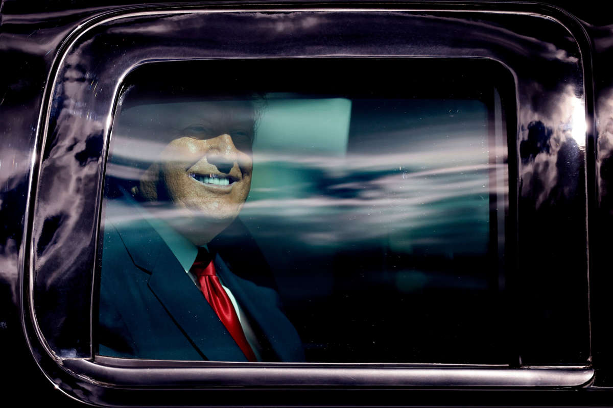 Outgoing President Trump waves to supporters lined along on the route to his Mar-a-Lago estate on January 20, 2021, in West Palm Beach, Florida.